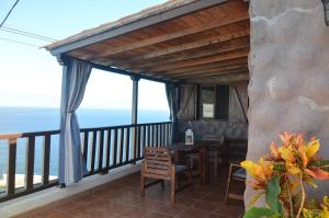 einen Balkon mit einem Tisch, Stühlen und Meerblick in der Unterkunft Terraza del Atlántico in Playa de Santiago
