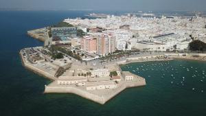 an aerial view of a city with boats in the water at El Balneario in Cádiz