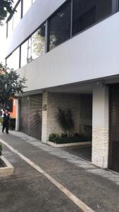 un homme debout devant un bâtiment dans l'établissement Suite G Mancera, à Mexico