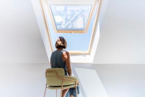a woman sitting on a chair looking out of a window at Fonda Llabres Boutique in Alcudia
