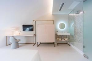 a white bathroom with a sink and a mirror at Fonda Llabres Boutique in Alcudia