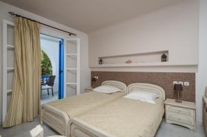 una camera con un grande letto e una finestra di Antonia Studios a Naxos Chora