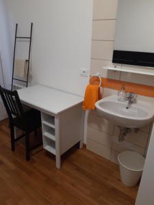 a bathroom with a sink and a desk and a sink at al 106 in Trieste