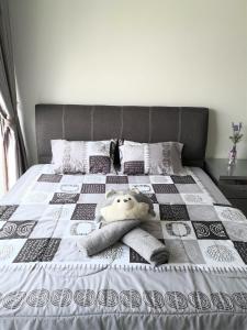 a stuffed animal is laying on a bed at Sparkling clean Homestay @ Kota Kemuning - Rimbayu in Teluk Panglima Garang