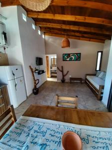 ein Wohnzimmer mit einem Bett und einer Küche in der Unterkunft CABAÑAS SUKHA in Santa Rosa de Calamuchita