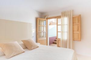 a bedroom with a white bed and an open door at Fonda Llabres Boutique in Alcudia