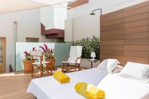 two beds in a room with chairs and a table at Fonda Llabres Boutique in Alcudia