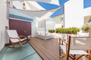 a balcony with chairs and a table on a building at Fonda Llabres Boutique in Alcudia