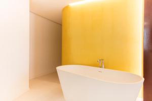 a bathroom with a white sink and a yellow wall at Fonda Llabres Boutique in Alcudia