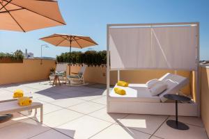 ein Schlafzimmer mit einem Bett und einem Sonnenschirm auf dem Dach in der Unterkunft Fonda Llabres Hostal Boutique in Alcúdia
