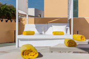 1 cama con almohadas amarillas en el balcón en Fonda Llabres Boutique en Alcúdia
