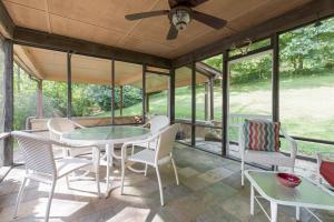 a screened in porch with a table and chairs at Anastasia in Hot Springs
