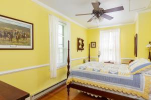 1 dormitorio amarillo con 1 cama y ventilador de techo en Anastasia en Hot Springs
