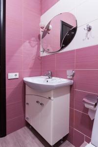 a pink bathroom with a sink and a mirror at Noy Hotel in Kharkiv