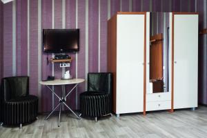 a room with two chairs and a table and a tv at Noy Hotel in Kharkiv