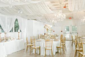a white room with tables and chairs and chandeliers at Georgia Palms & Gardens in Powder Springs