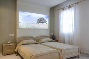 a bedroom with two beds and a large window at Antonia Studios in Naxos Chora