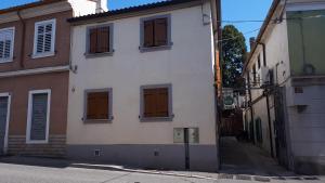 Un edificio blanco con puertas marrones en una calle. en al 106, en Trieste