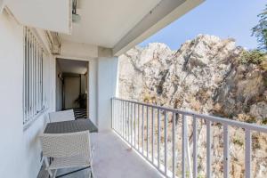 a balcony with two chairs and a mountain at T2 SUPERBE VUE MER et Vallon Des Auffes in Marseille
