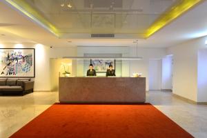 a lobby with a reception desk and a red rug at Pestana Cidadela Cascais - Pousada & Art District in Cascais +37 photos