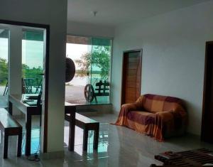 a living room with a chair and a table at hotel Casa do Francês na Praia in Boa Vista