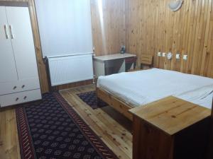 1 dormitorio con cama, escritorio y lavamanos en Kaçkar Pansiyon, en Yaylalar