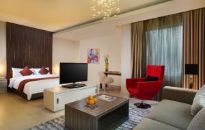ein Hotelzimmer mit einem Bett und einem roten Stuhl in der Unterkunft Patra Bandung Hotel in Bandung