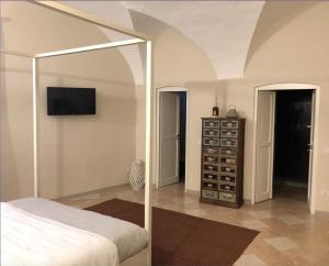 a bedroom with a bed and a cabinet with wine bottles at R&B Il Viavai in Mondovì