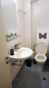 a bathroom with a sink and a toilet with a butterfly on the wall at Feels like home in Kalamata