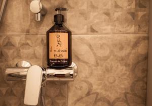 a bottle of alcohol sitting on a holder in a bathroom at R&B Il Viavai in Mondovì