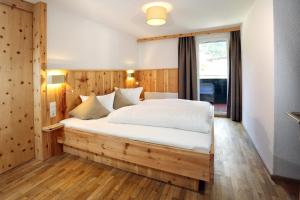 a bedroom with a large white bed in a room at Berghotel-Gasthof Gstrein in Vent