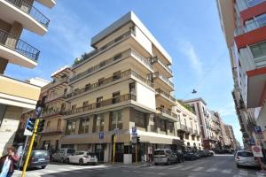 a tall building on a city street with parked cars at NICOLA'S APARTMENTS in Bari