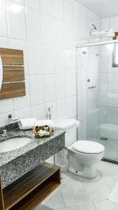 a bathroom with a toilet and a sink and a shower at Pousada Lusitânia in Pedra Azul +35 photos