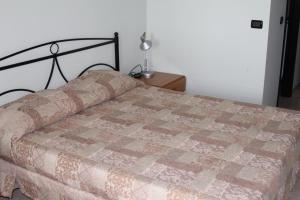 Una cama con edredón en un dormitorio en Agriturismo Silos Agri, en San Severo