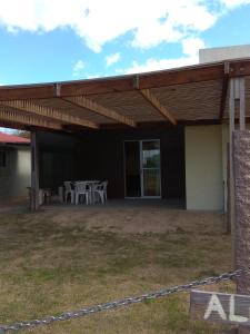 a patio with a table and chairs under a roof at Cabaña Gabon in Barra del Chuy