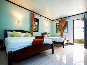 2 Betten in einem Schlafzimmer mit blauen Wänden und Fenstern in der Unterkunft Lanta Coral Beach Resort in Ko Lanta