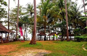 um grupo de palmeiras e um grupo de cabanas em Lanta Coral Beach Resort em Ko Lanta