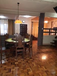 a dining room with a table and chairs and a clock at Zya 3BR A-House in Baguio