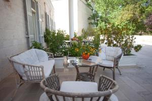 patio z krzesłami, stołem i krzesłami w obiekcie Villa Rosato w mieście Selva di Fasano