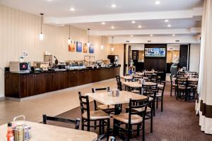 Comfort Inn & Suites في Fox Creek: مطعم بطاولات وكراسي وكاونتر