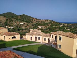 einen Blick auf ein Haus mit einem Berg im Hintergrund in der Unterkunft Hotel Punta Moros in Tertenìa