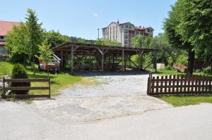 a wooden pavilion in a field with a fence at Apartmani LUX in Kolašin