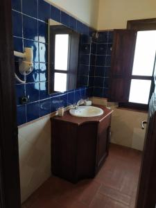 a bathroom with a sink and a mirror at Hotel Punta Moros in Tertenìa