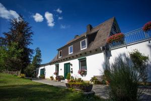 Casa blanca con puertas verdes y techo en Pension Haus am Walde en Schmallenberg