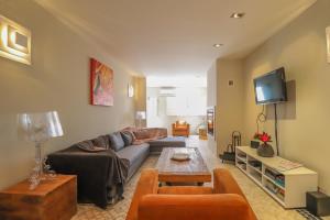 a living room with a couch and a tv at Villa Zawaia B&B in Lagos