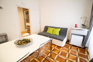 ein Wohnzimmer mit einem Sofa und einem Tisch in der Unterkunft Maison Amelie in Triest