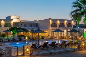 a hotel with a pool with chairs and umbrellas at Christiana Hotel in Ambelas