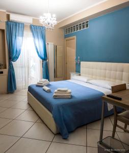Un dormitorio azul con una cama con toallas. en Blu Mediterraneo B&B, en Messina