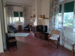a living room with a tv and chairs and windows at Casa "Le Terrazze" in Erice