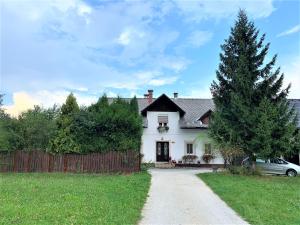 a white house with a fence and a driveway at Apartment Mary in Bled
